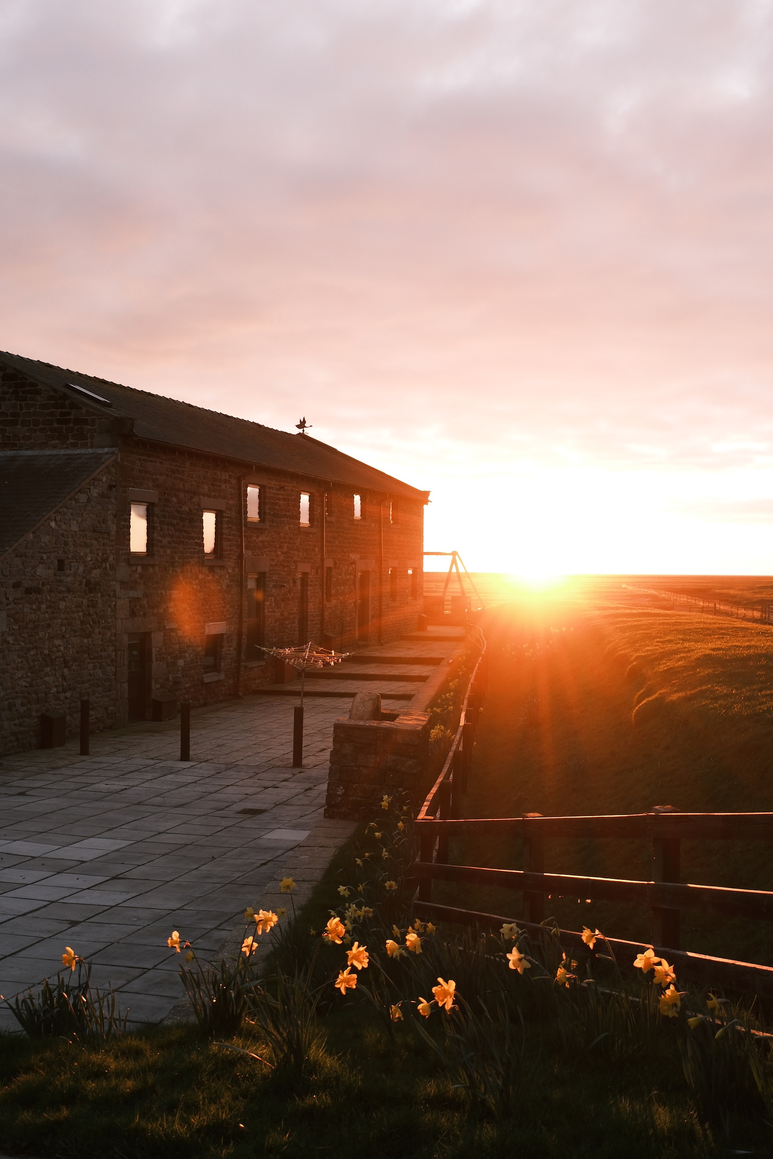 Sunset over the stone holiday cottages and salt marshes at Patty’s Barn